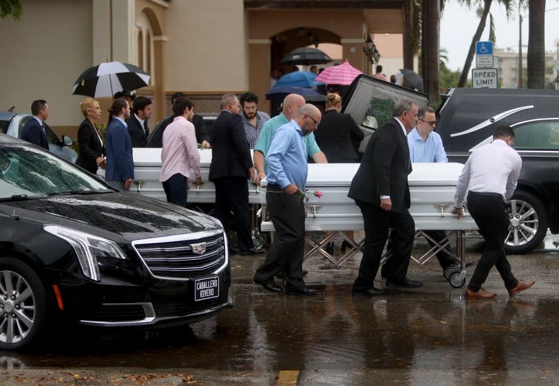 SURFSIDE, FLORIDA - JULY 06: Pallbearers bring two of three caskets to the hearse after the funeral at St. Joseph Catholic Church for Anaely Rodriguez her husband Marcus Guara and their daughters Lucia Guara, and Emma Guara after the family was killed in the partially collapsed 12-story Champlain Towers South condo on July 06, 2021 in Miami Beach, Florida. Over one hundred people are missing as the search-and-rescue effort continues. (Photo by Joe Raedle/Getty Images)