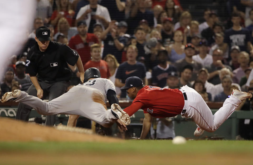 Boston Red Sox third baseman Rafael Devers, right, makes the tag out on New York Yankees' Luke Voit trying to get to third base on a single by Gleyber Torres in the eighth inning of a baseball game at Fenway Park, Friday, July 26, 2019, in Boston. (AP Photo/Elise Amendola)