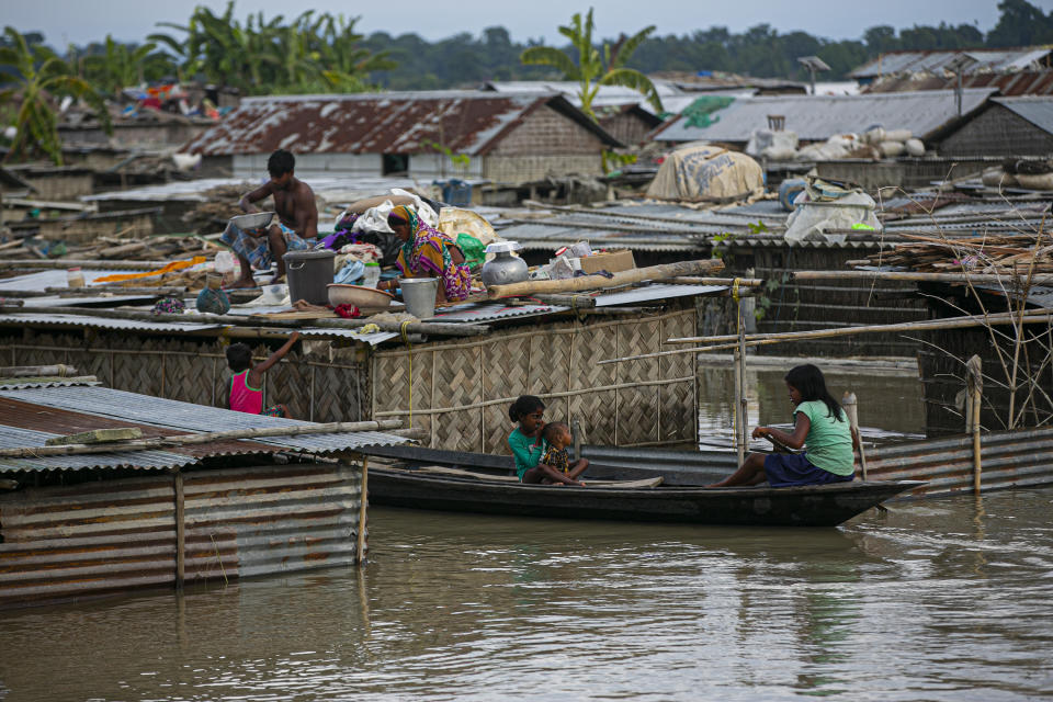 A flood affected family takes shelter on the roof of their partially submerged house along river Brahmaputra in Morigaon district, Assam, India, Thursday, July 16, 2020. Floods and landslides triggered by heavy monsoon rains have killed dozens of people in this northeastern region. (AP Photo/Anupam Nath)