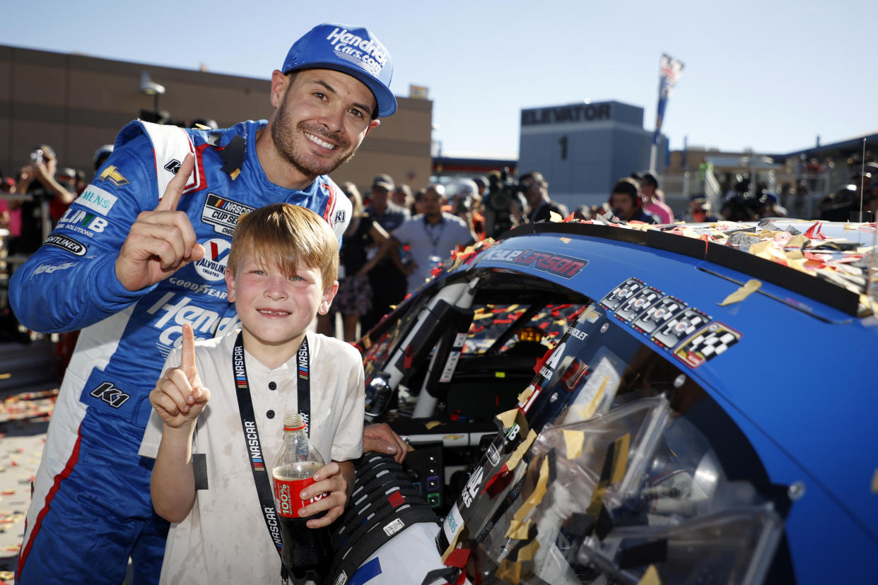 LAS VEGAS, NEVADA - OCTOBER 15: Kyle Larson, driver of the #5 HendrickCars.com Chevrolet, and son, Owen Larson pose with the winner sticker on his car in victory lane after winning the NASCAR Cup Series South Point 400 at Las Vegas Motor Speedway on October 15, 2023 in Las Vegas, Nevada. (Photo by Chris Graythen/Getty Images)