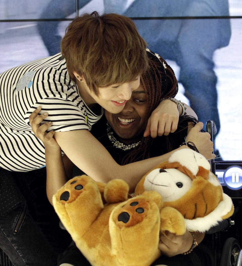 Donika Sterling from New York, right, gets a hug from Tae Min, her most favorite member of South Korean pop group SHINee after their meeting in Seoul, South Korea, Wednesday, June 20, 2012. The 15 year-old American K-pop fan, who is suffering a disease that gradually causes loss of muscle tissue and slows down parts of the body, met and sang with the boy band she idolizes. (AP Photo/Lee Jin-man)