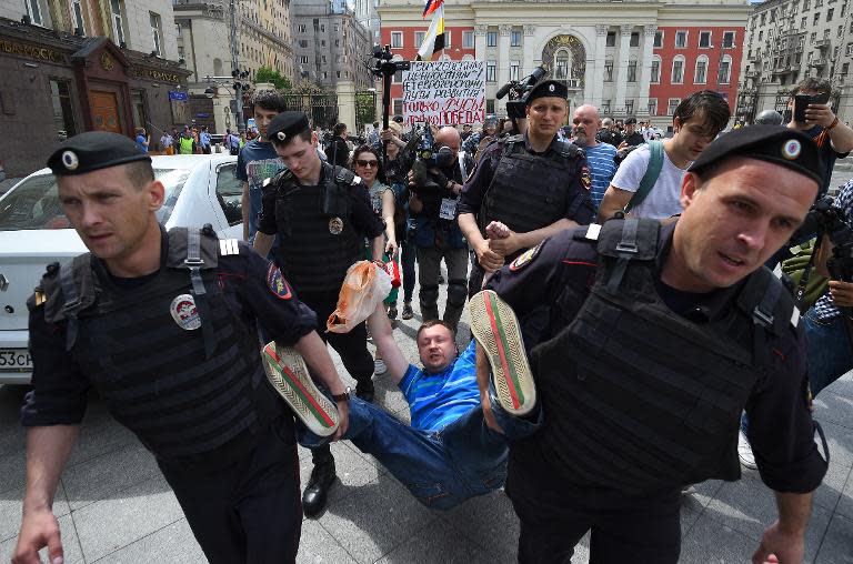 Russian riot policemen detain gay and LGBT rights activist Nikolai Alexeyev (C) during an unauthorized gay rights activists rally in central Moscow on May 30, 2015