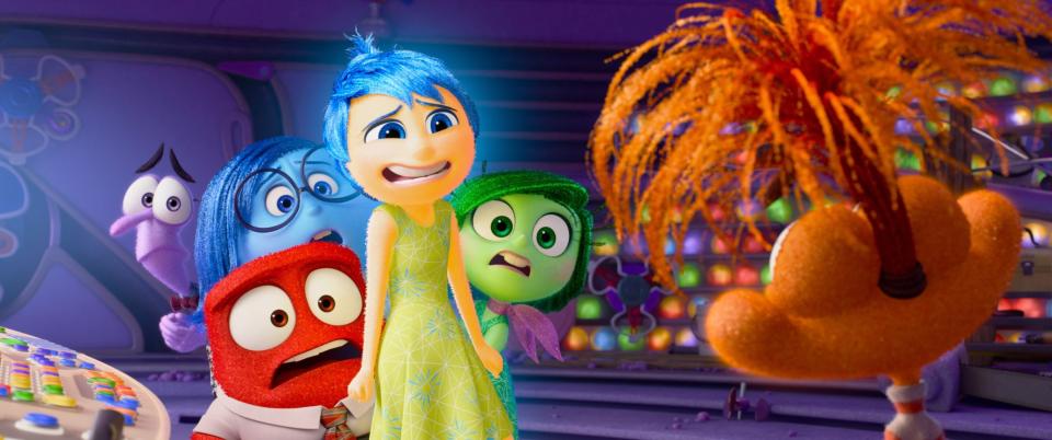 Animated characters Joy, Sadness, Anger, Fear, and Disgust from the movie Inside Out standing together