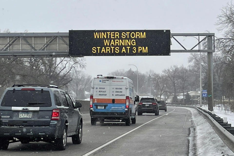 Vehicles pass a sign that reads "WINTER STORM WARNING STARTS AT 3PM" along Interstate Highway 35 near the Minneapolis-Saint Paul International Airport in Minn., on Feb. 21, 2023, ahead of a winter storm that took aim at the Upper Midwest. The storm threatened to bring blizzard conditions, bitterly cold temperatures and 2 feet of snow in a three-day onslaught that could affect more than 40 million Americans. (AP Photo/Trisha Ahmed)