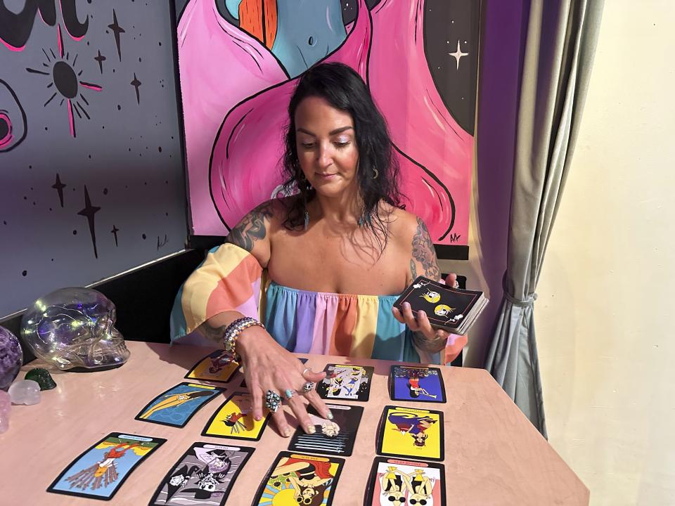 Ashley Branton lays out tarot cards in the back of her shop, Velvet Witch, in Norfolk, Va., Thursday, June 13, 2024. The city of Norfolk recently repealed its 45-year-old ban on “the practice of palmistry, palm reading, phrenology or clairvoyance, for monetary or other compensation.” The 1979 ordinance was not being enforced, however, and the psychic services industry is growing. (AP Photo/Ben Finley)