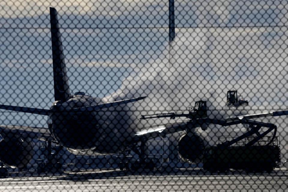 A Lufthansa aircraft is de-iced at the airport in Munich, Germany, Tuesday, Dec. 5, 2023.Munich Airport temporarily suspended flight operations on Tuesday morning due to freezing rain as cold weather continued in the region. (AP Photo/Matthias Schrader)