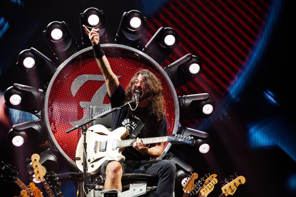 Foo Fighters frontman Dave Grohl sings during a 2015 concert at Chesapeake Energy Arena (now Paycom Center) in photo by Oklahoma City photographer and journalist Nathan Poppe. Grohl played the show sitting on a throne decorated with guitar necks and moving lights due to a broken leg he suffered earlier that year while on tour. Nathan Poppe photo