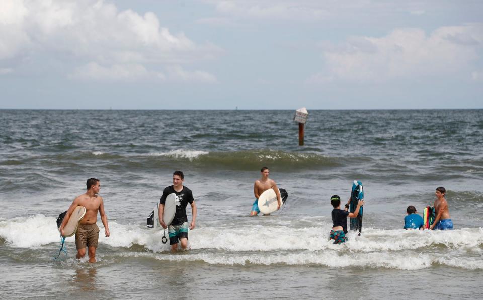 Surfers and boogie boarders in the water at the North Beach of Tybee Island.