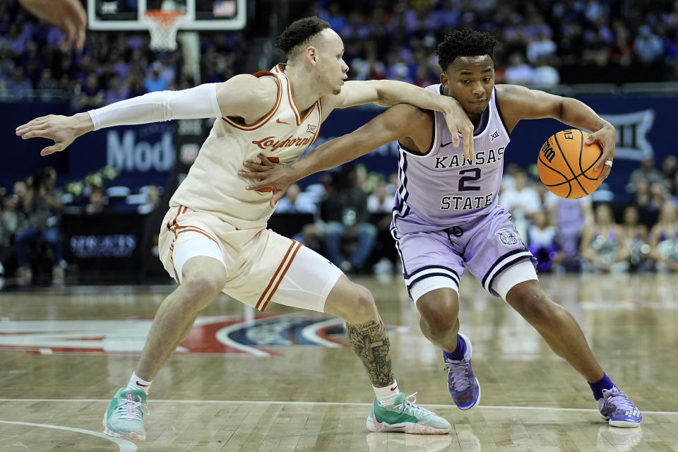 Kansas State guard Tylor Perry (2) tries to get around Texas guard Chendall Weaver, left, during the first half of an NCAA college basketball game Wednesday, March 13, 2024, in Kansas City, Mo. (AP Photo/Charlie Riedel)