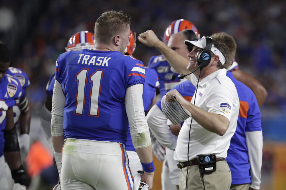 Florida head coach Dan Mullen, right, talks with quarterback Kyle Trask (11) during the first half of the Orange Bowl NCAA college football game against Virginia, Monday, Dec. 30, 2019, in Miami Gardens, Fla. (AP Photo/Lynne Sladky)