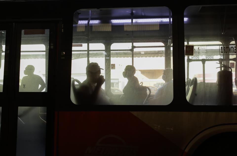 Commuters wearing face masks amid the new coronavirus pandemic ride on a bus at the main terminal in Panama City, Monday, June 1, 2020. The Central American country reactivated a second block of activities on Monday, significantly easing mobility restrictions in place since March. (AP Photo/Arnulfo Franco)