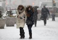 People walk through heavy falling snow in Times Square in New York January 26, 2015. REUTERS/Mike Segar