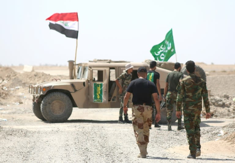 Members of the Popular Mobilisation units gather around a vehicle during a military operation against Islamic State (IS) group jihadists north of Fallujah, in Iraq's Anbar province, on August 19, 2015