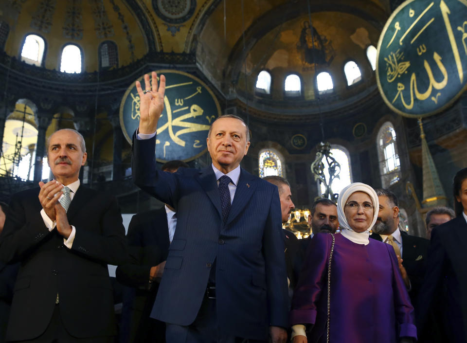 FILE - In this Saturday, March 31, 2018 file photo, Turkey's President Recep Tayyip Erdogan, centre, accompanied by his wife Emine, right, waves to supporters as he walks in the Byzantine-era Hagia Sophia, an UNESCO world heritage site and one of Istanbul's main tourist attractions, in the historic Sultanahmet district of Istanbul. The 6th-century building is now at the center of a heated debate between conservative groups who want it to be reconverted into a mosque and those who believe the World Heritage site should remain a museum. (Kayhan Ozer/Pool Photo via AP, File)
