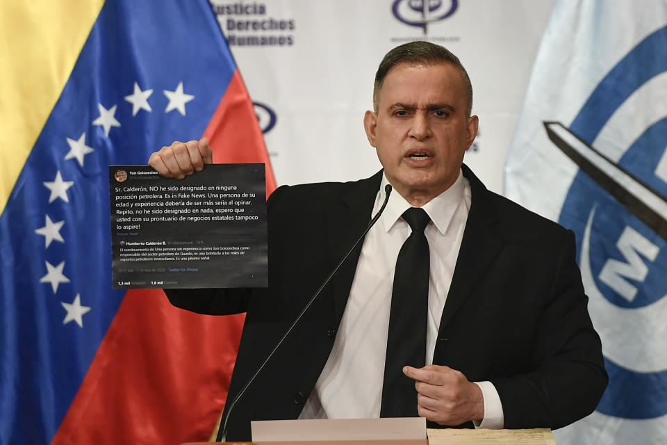 Venezuela's Attorney General Tarek William Saab holds up twitter posts during a press conference regarding what the government calls a failed attack over the weekend aimed at overthrowing President Nicolás Maduro in Caracas, Venezuela, Monday, May 4, 2020. The twitter posts are between two members of the opposition, Humberto Calderon and Yon Goicoechea. (AP Photo/Matias Delacroix)