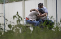 A couple embraces as they wait for information about missing relatives after a massive slab of rock broke away from a cliff and toppled onto pleasure boaters at Furnas reservoir on Saturday, killing at least seven people, near Capitolio city, Brazil, Sunday, Jan. 9, 2022. (AP Photo/Igor do Vale)