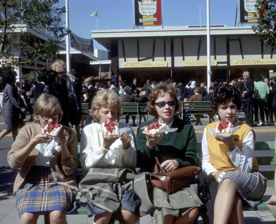 In this October 1964 photo provided by worldsfairphotos.com, four girls eat Belgian Waffles on the Grounds of the World’s Fair in the Queens Borough of New York. Belgian Waffles were introduced to the American public at the fair by Belgian Maurice and Rose Vermersch and their daughter MariePaule. (AP Photo/Bill Cotter) MANDATORY CREDIT, NO SALES