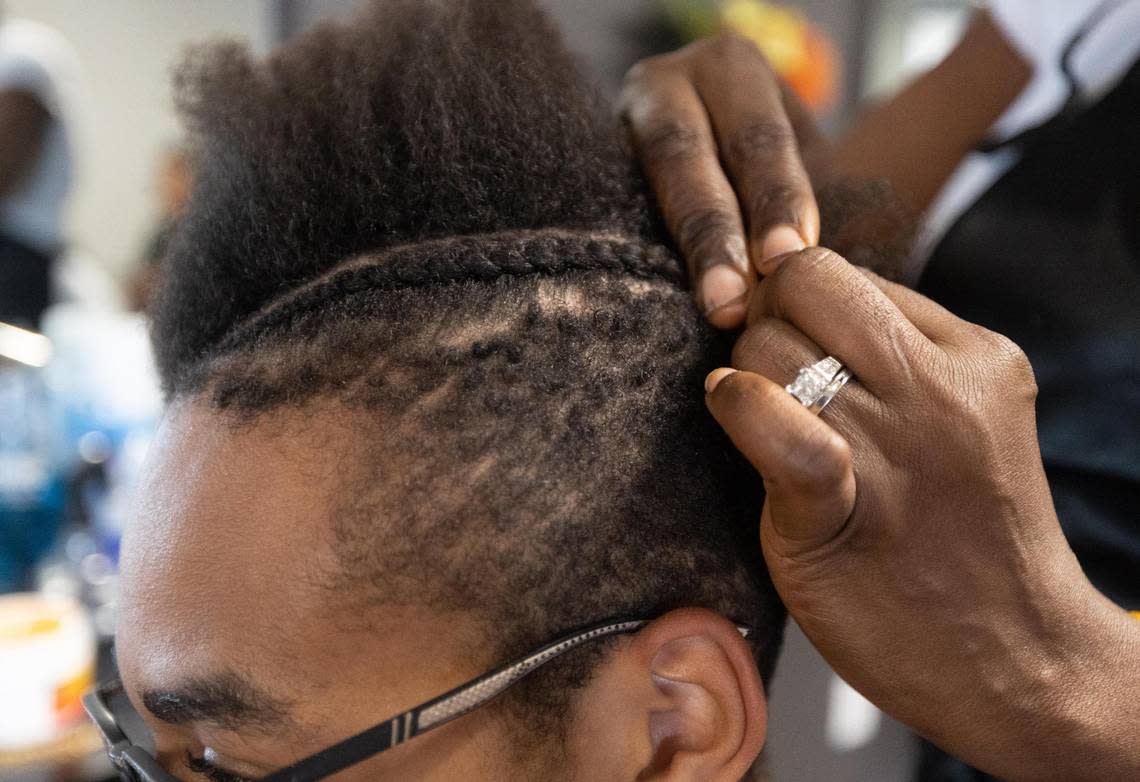 Comfort Corder braids Royce Jackson’s hair Monday, Sept. 12, 2022, at Coco’s Braiding & Styling Salon in Arlington.