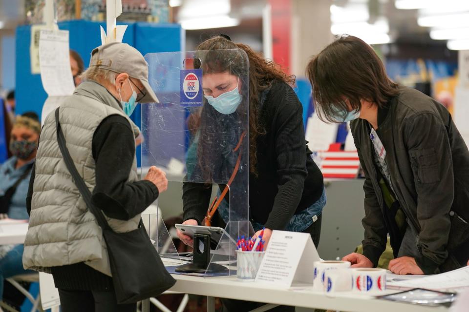 Poll workers help voters at a polling place in New York, Tuesday, Nov. 2, 2021. (AP Photo/Seth Wenig) ORG XMIT: NYSW120