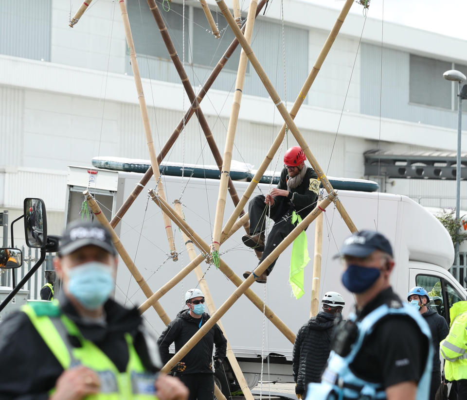 One of the protesters climbs down from the bamboo lock-ons they are using to block the road outside the Newsprinters printing works at Broxbourne, Hertfordshire. (Photo by Yui Mok/PA Images via Getty Images)