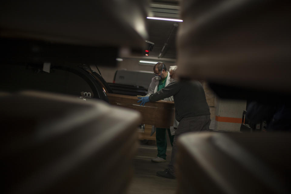 A coffin containing a victim of COVID-19 is loaded into a hurse in the parking garage at the Collserola funeral parlour in Montcada i Reixac, near Barcelona.  (José Colon for Yahoo News)