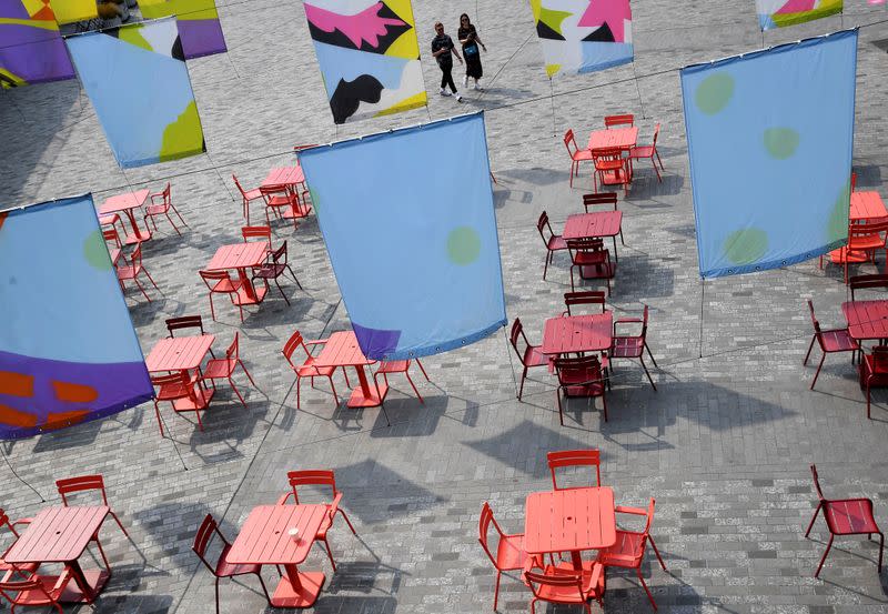 FILE PHOTO: People walk towards an empty socially-distanced arranged outdoor seating area whilst the reproduction "R" number of COVID-19 infections in the United Kingdom has risen and may be above 1, London, Britain