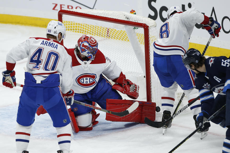 Montreal Canadiens goaltender Carey Price (31) saves a shot as Winnipeg Jets' Mark Scheifele (55) looks on during second-period NHL hockey game action in Winnipeg, Manitoba, Thursday, Feb. 25, 2021. (John Woods/The Canadian Press via AP)