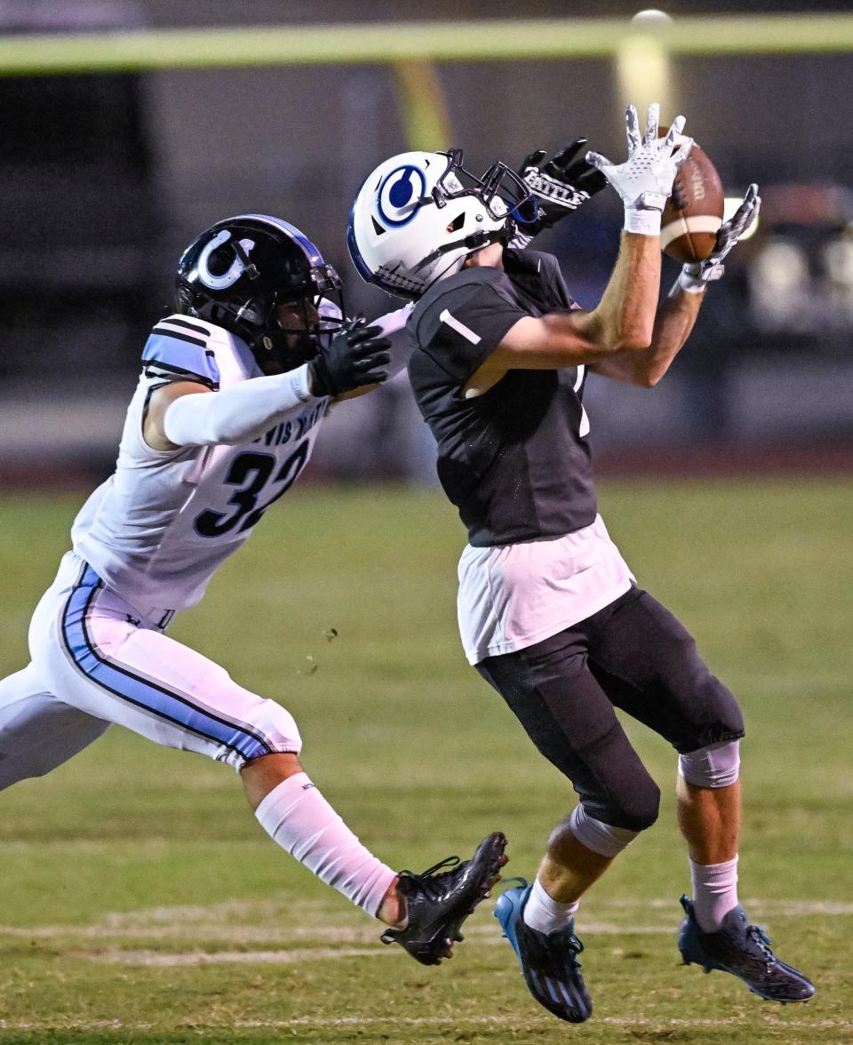 Central Valley Christian's Bryce Crook takes a pass under pressure from Clovis North's Cannon Parks in a non-league high school football game Friday, September 8, 2023.