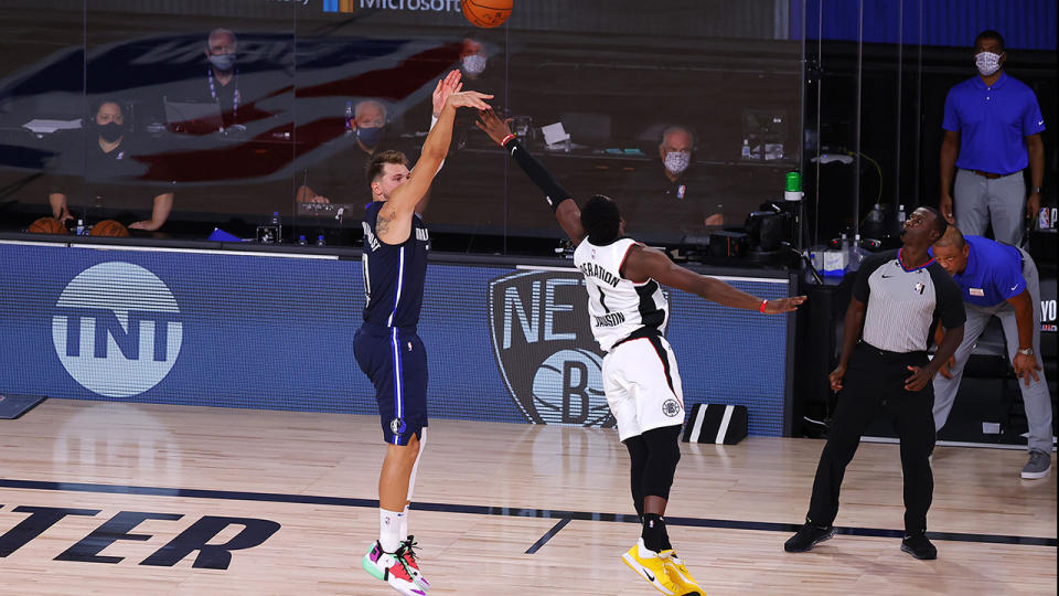 Luka Doncic is pictured shooting over LA Clippers opponent Reggie Jackson to win the game.