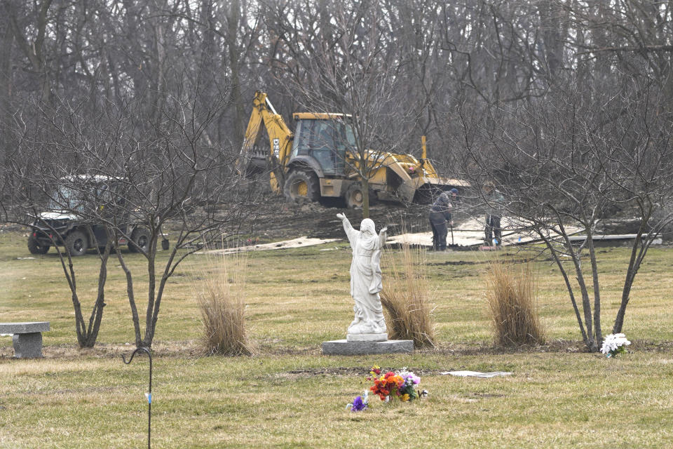 Cemetery workers prepare Wednesday, March 17, 2021, for an interment at the historic Mount Glenwood cemetery in Glenwood, Ill. The cemetery was formed in 1908 by a group of Black businessmen with an explicit nondiscrimination clause in its charter. (AP Photo/Charles Rex Arbogast)