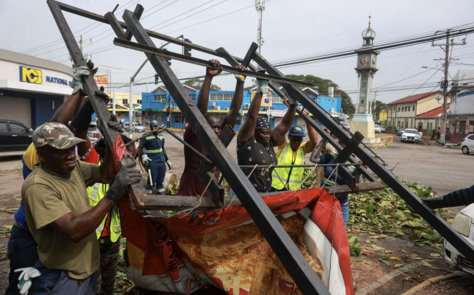 Jamaicans clearing up on Thursday in Old Harbor after Hurricane Beryl had passed