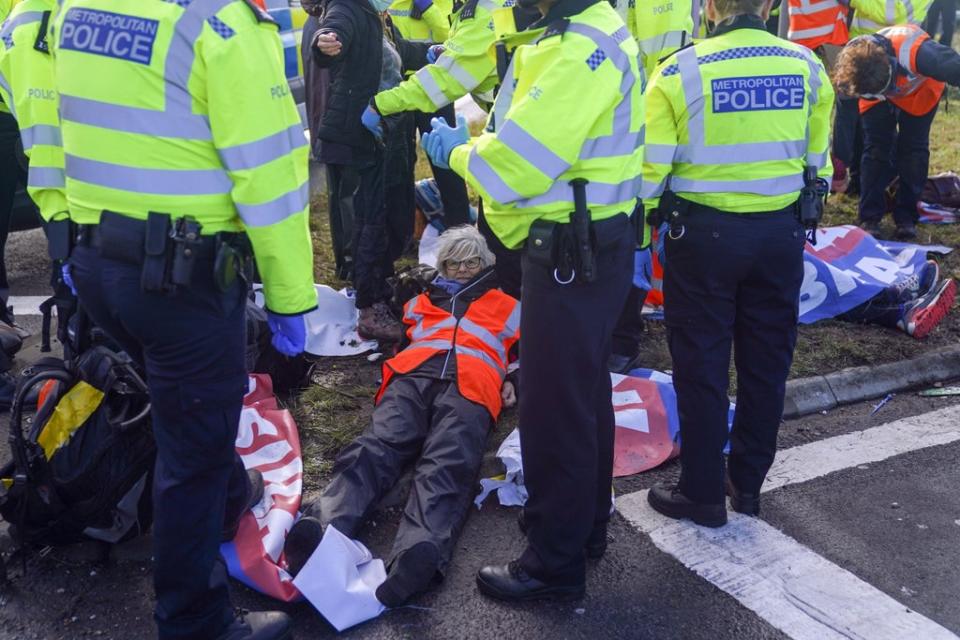 Police detain a protester from Insulate Britain occupying a roundabout leading from the M25 to Heathrow (Steve Parsons/PA) (PA Wire)