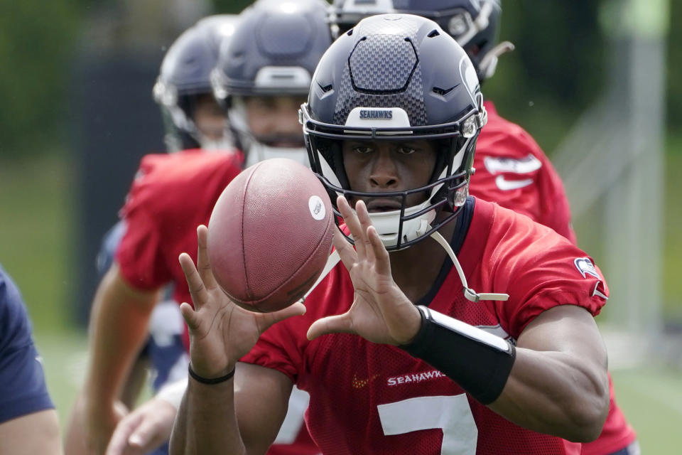 Seattle Seahawks quarterback Geno Smith reaches for the football during NFL football practice Wednesday, June 8, 2022, in Renton, Wash. (AP Photo/Ted S. Warren)