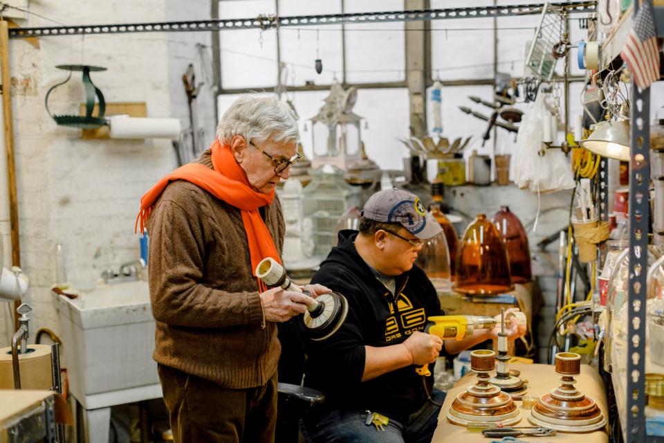 Rosselli inspects an object at his workshop on 119th Street.