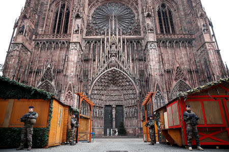 French soldiers stand guard near closed wooden barracks shops at the traditional Christkindelsmaerik (Christ Child market) in front of the Cathedral the day after a shooting in Strasbourg, France, December 12, 2018. REUTERS/Christian Hartmann