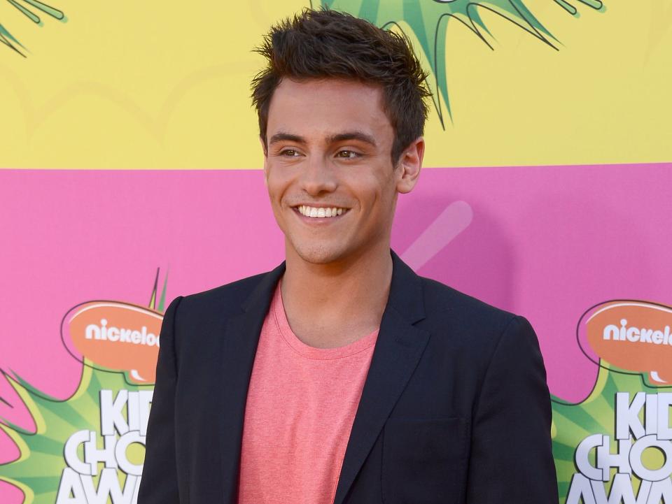 Tom Daley at the Nickelodeon Kid's Choice Awards in 2013 wearing a uit jacket and pink shirt