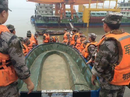 Rescue workers carry a boat as they conduct a search, after a ship sank in the Jianli section of the Yangtze River, Hubei province, China, June 2, 2015. The passenger ship carrying 458 people, many elderly Chinese tourists, sank in the Yangtze River on Monday night during a storm and only 12 people had been rescued so far, state media said. REUTERS/Chen Zhuo/Yangzi River Daily CHINA OUT. NO COMMERCIAL OR EDITORIAL SALES IN CHINA