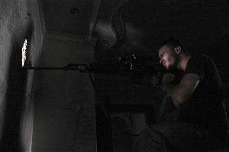 A Free Syrian Army sniper is seen in shooting position in Aleppo's Al-Ezaa front line, September 1, 2013. REUTERS/Malek Alshemali