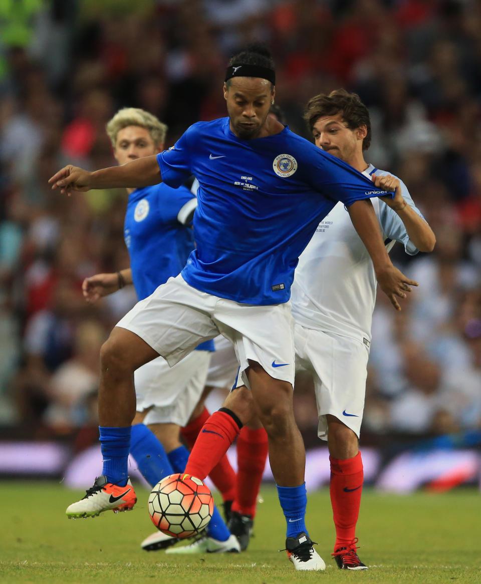 Rest of the World's Ronaldinho and England's Louis Tomlinson (right) battle for the ball during Soccer Aid 2016 at Old Trafford, Manchester.