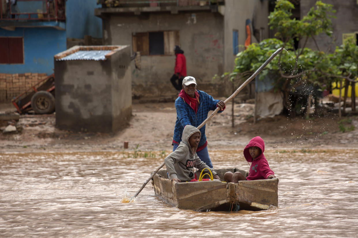 A man steers his boat that is used by residents to move around the street flooded with rain water in Antananarivo, Madagascar, Saturday, Jan. 28, 2023. A tropical storm Cheneso made landfall across north-eastern Madagascar on January 19, brought strong winds to coastal regions, while heavy rain brought significant flooding to northern parts of the country. (AP Photo/Alexander Joe)