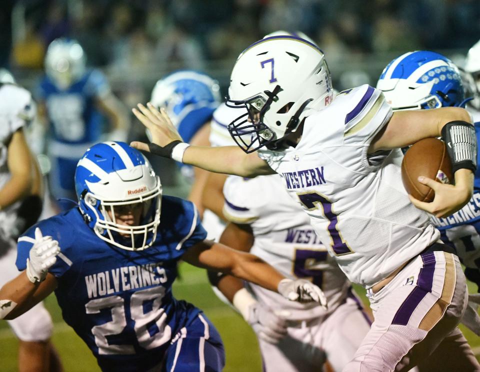  Western Beaver’s Jaivin Peel stiff arms Ellwood’s Ethan Patterson during Friday night’s game at Ellwood.