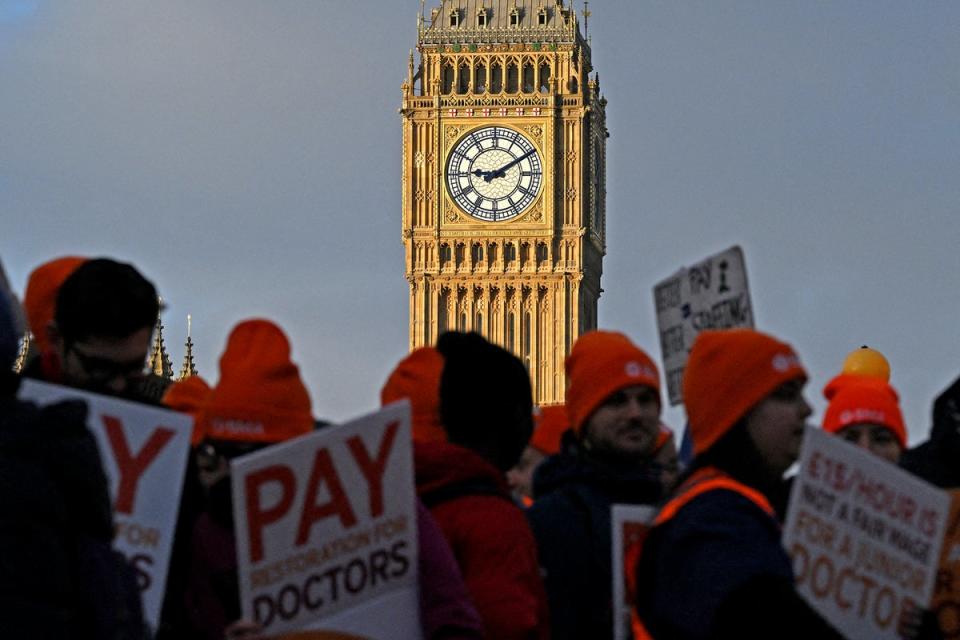 People hold placards calling for better pay, as they stand on a picket line outside St Thomas' Hospital in central London on January 3, 2024, on the first day of six days of strike action (AFP via Getty Images)