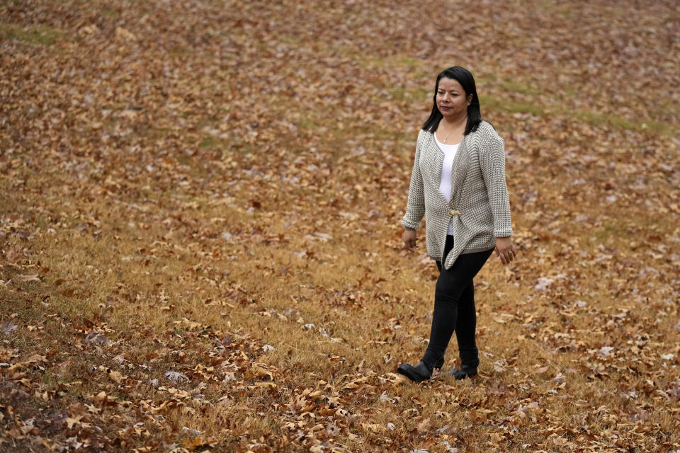 Abi Suddarth walks through the leaves at Wyandotte County Lake, Friday, Nov. 4, 2022, in Kansas City, Kan. Suddarth is still undecided how she will vote in the upcoming election, citing divisiveness among political parties and a need for the country to find common ground. (AP Photo/Charlie Riedel)