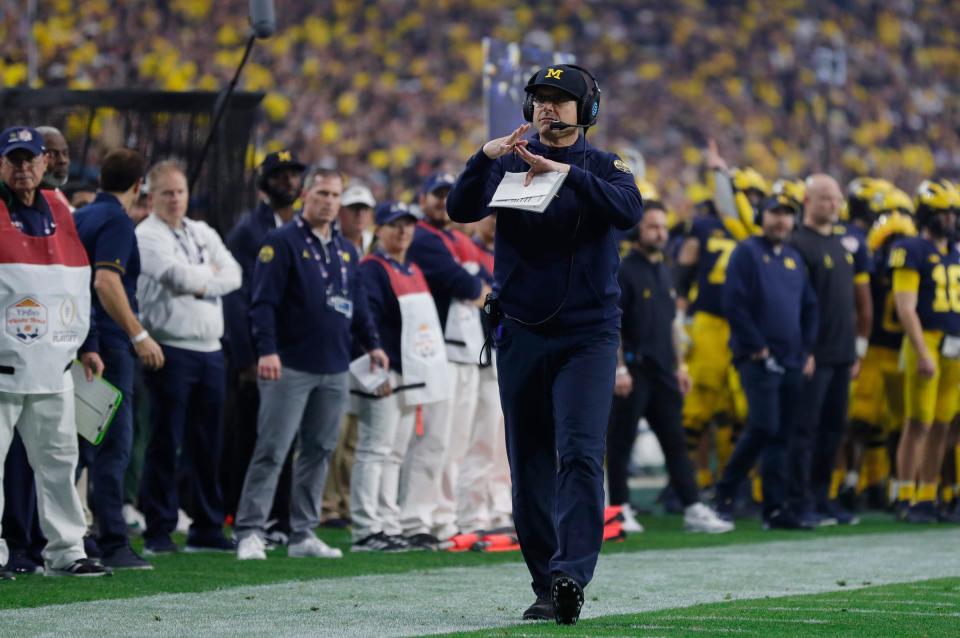 Michigan head coach Jim Harbaugh signals for a timeout  in the first quarter against TCU during the Fiesta Bowl on Saturday, Dec. 31 at State Farm Stadium in Glendale, Ariz.