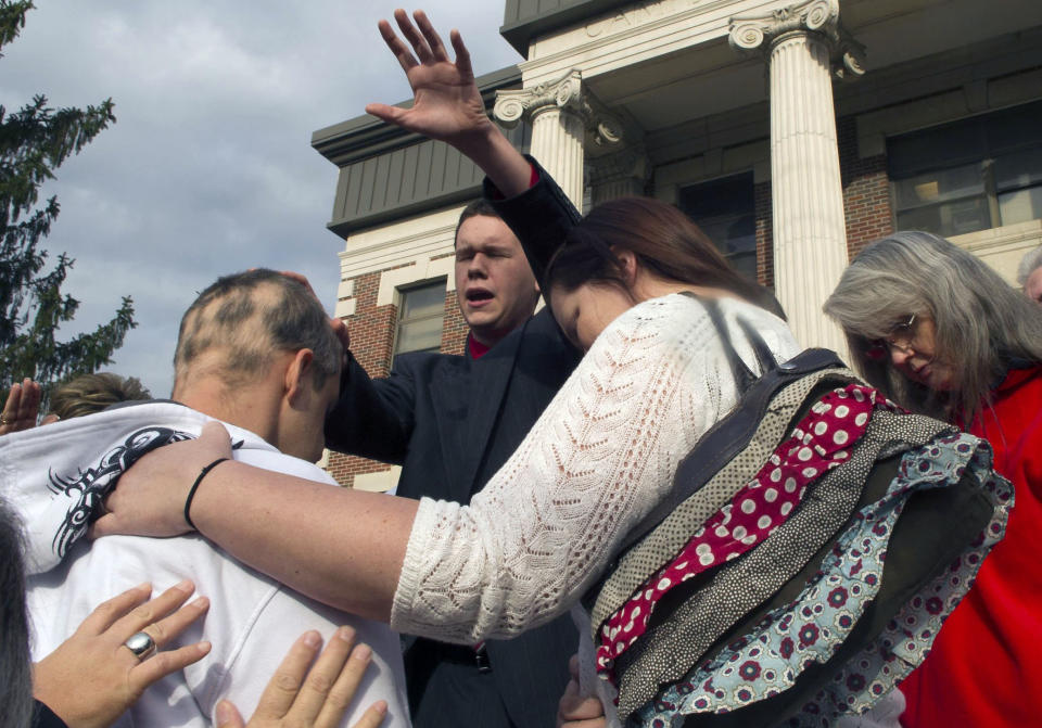 FILE - In this Friday Nov. 15, 2013 file photo, Tabernacle Church of God Pastor Andrew Hamblin leads a prayer circle around Ronnie Vaught of Corbin, Ky. in Jacksboro, Tenn. Hamblin, who appears on the National Geographic reality television show "Snake Salvation," is charged with possession of Class 1 wildlife after more than 50 venomous snakes were confiscated from his church. (AP Photo/Knoxville News Sentinel, J. Miles Cary)