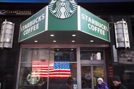 Pedestrians walk past a Starbucks store in the Manhattan borough of New York January 24, 2014. REUTERS/Lucas Jackson