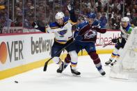 St. Louis Blues center Tyler Bozak (21) tangles with Colorado Avalanche defenseman Josh Manson (42) along the boards during the first period in Game 2 of an NHL hockey Stanley Cup second-round playoff series Thursday, May 19, 2022, in Denver. (AP Photo/Jack Dempsey)