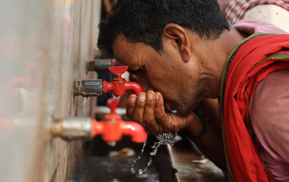 A laborer drinks from a public drinking water tap on a hot day in the old quarters of Delhi, India, May 4, 2022. / Credit: Reuters/Anushree Fadnavis