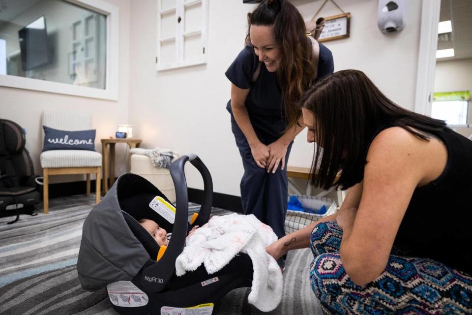 Ashlee Hussen and Melissa Cornell, director, look at Olivia in her carrier June 9, 2022, at Fellowship of the Parks. The daycare started as part of SigmaPro Engineering and Manufacturing during the pandemic.