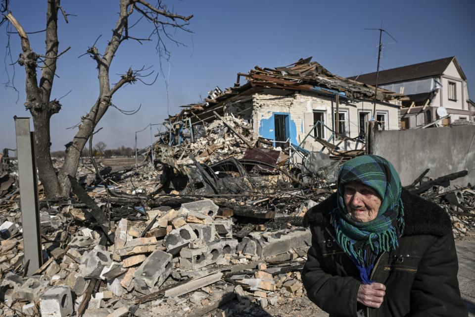 An eldery woman stands in front of a destroyed house after bombardments in Krasylivka, east of Kyiv.